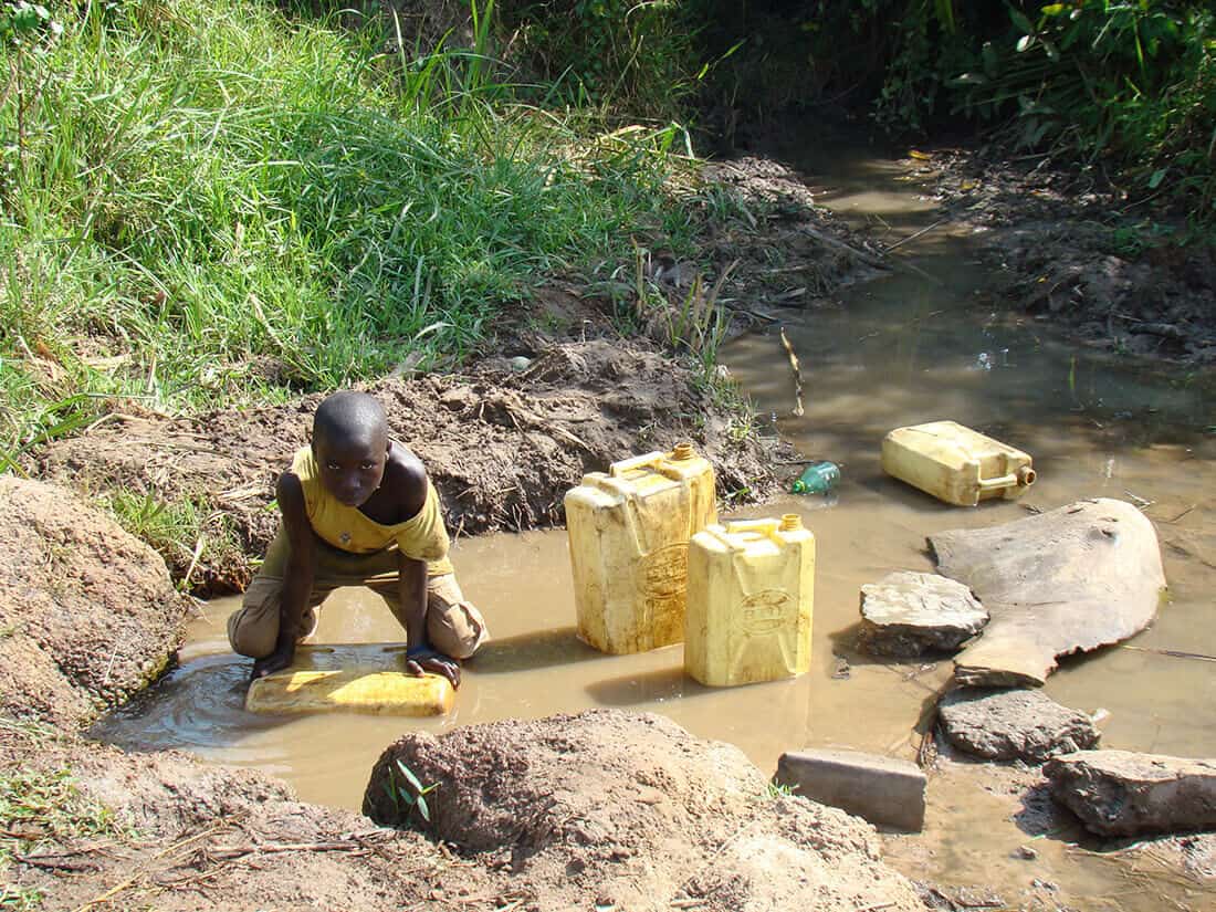 African child filling muddy water