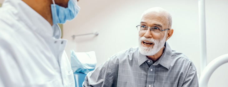 Older gentleman speaking with the dentist