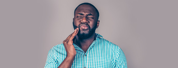 Man in pain holding his jaw