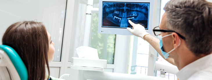 Dentist showing his patient an X-Ray